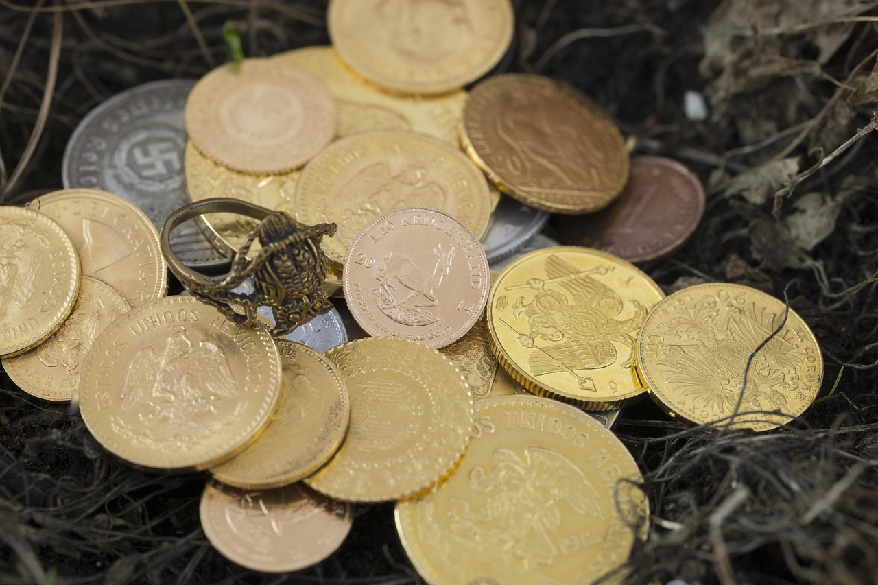 Stack of gold coins scattered across a dark surface, representing long-term retirement investing.