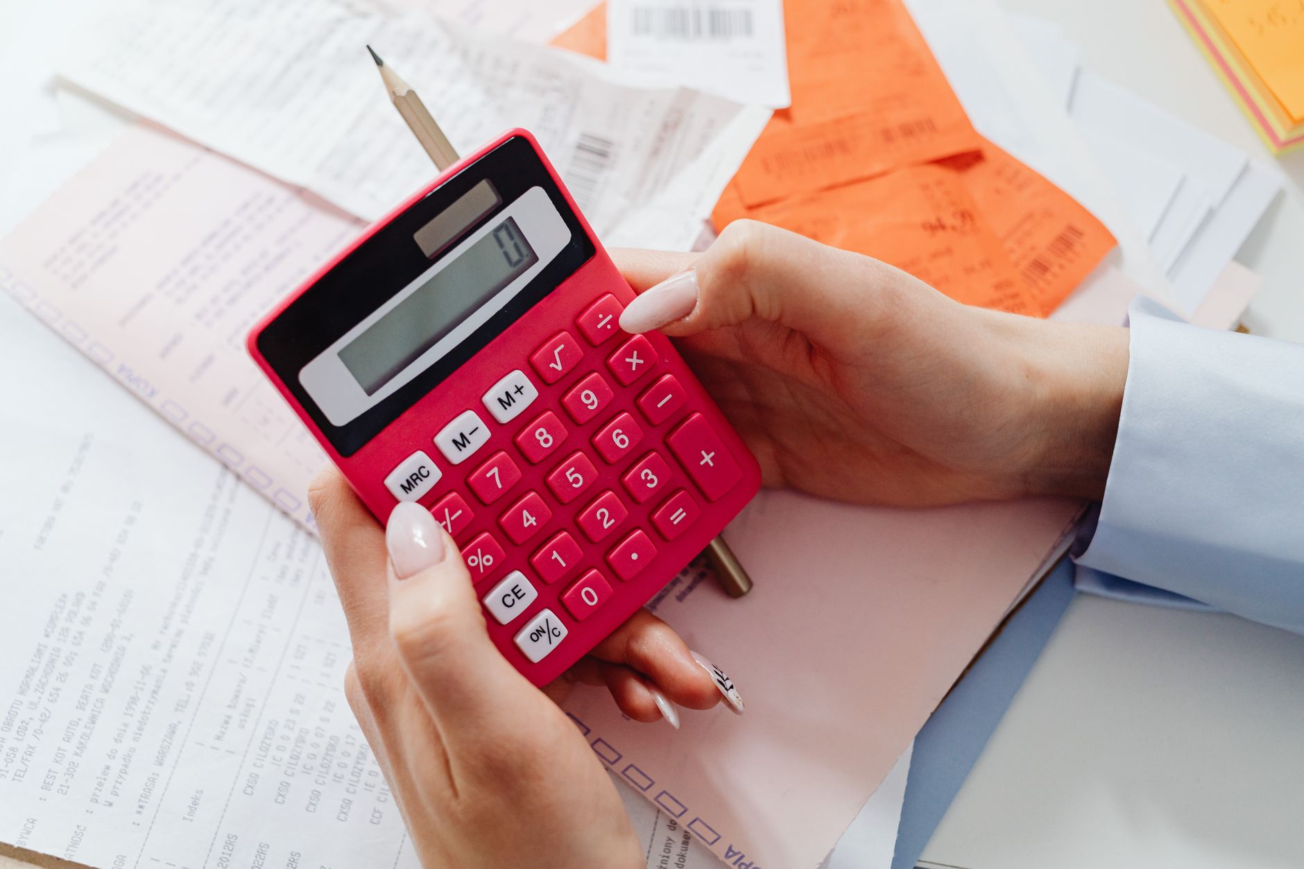 A calculator sitting on top of loan paperwork showing monthly payment calculations.