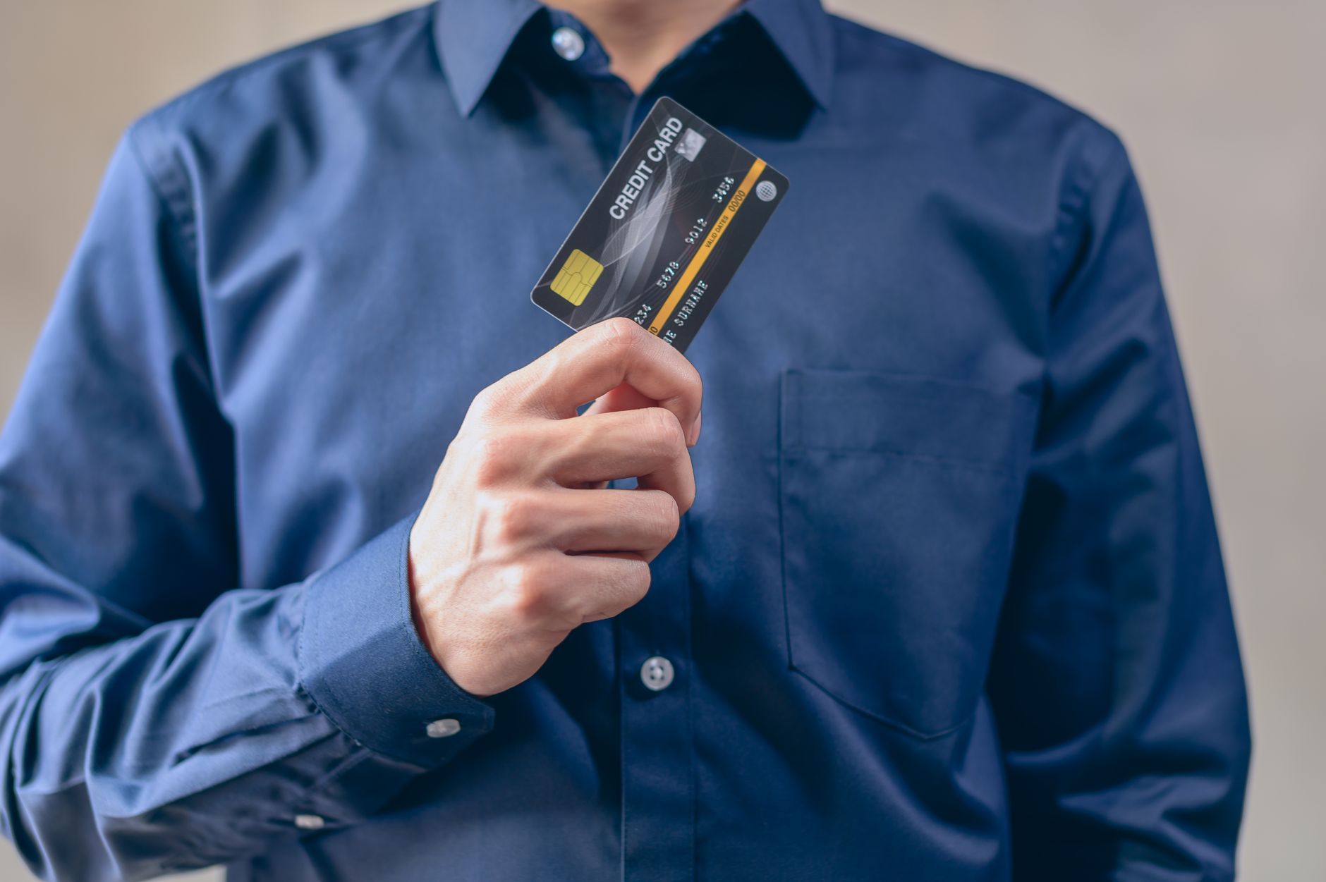 A secured credit card being handed over a counter, showing a deposit being made.