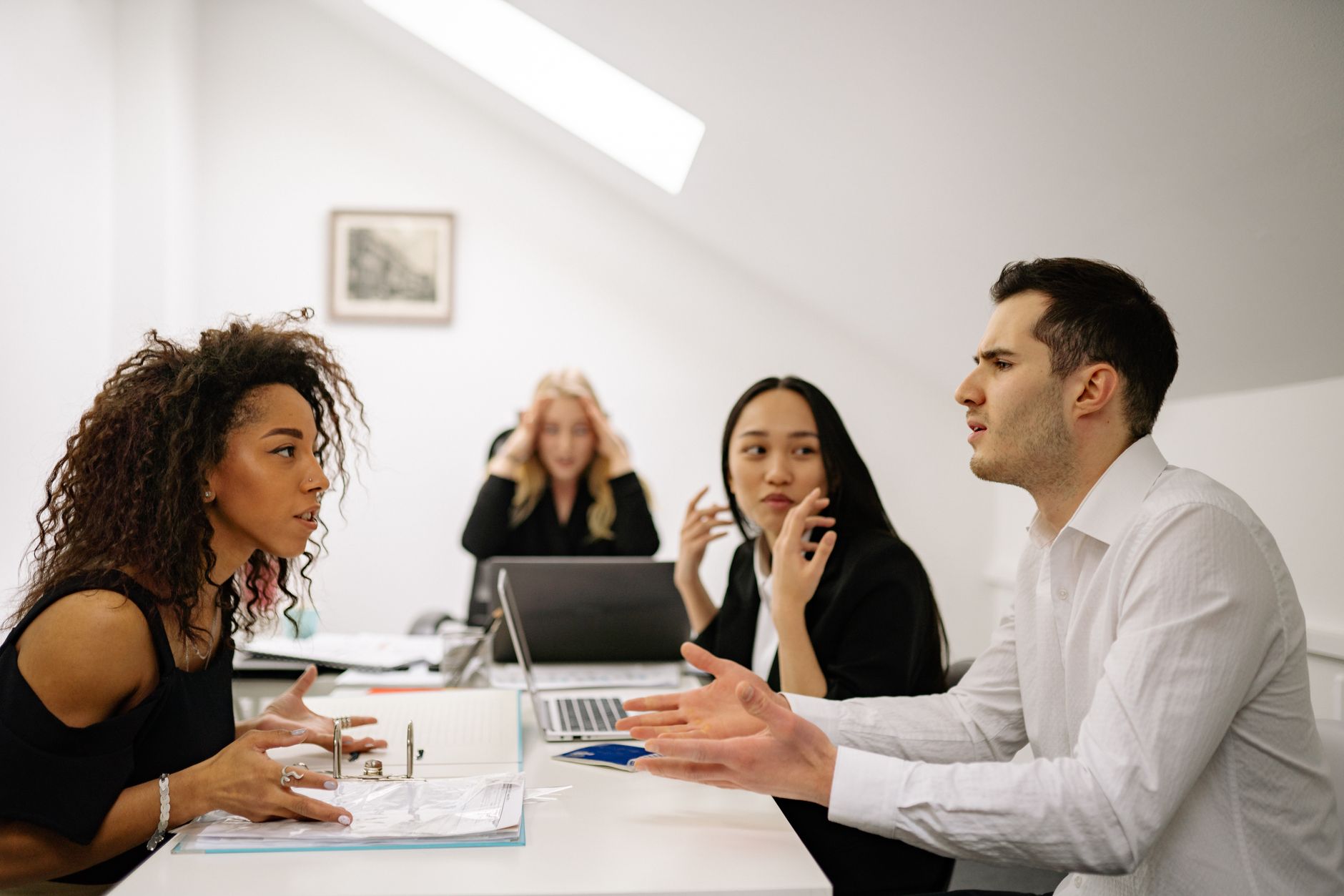 An anxious employee sitting across from a manager in a modern office, representing the fear many feel when initiating salary negotiation conversations
