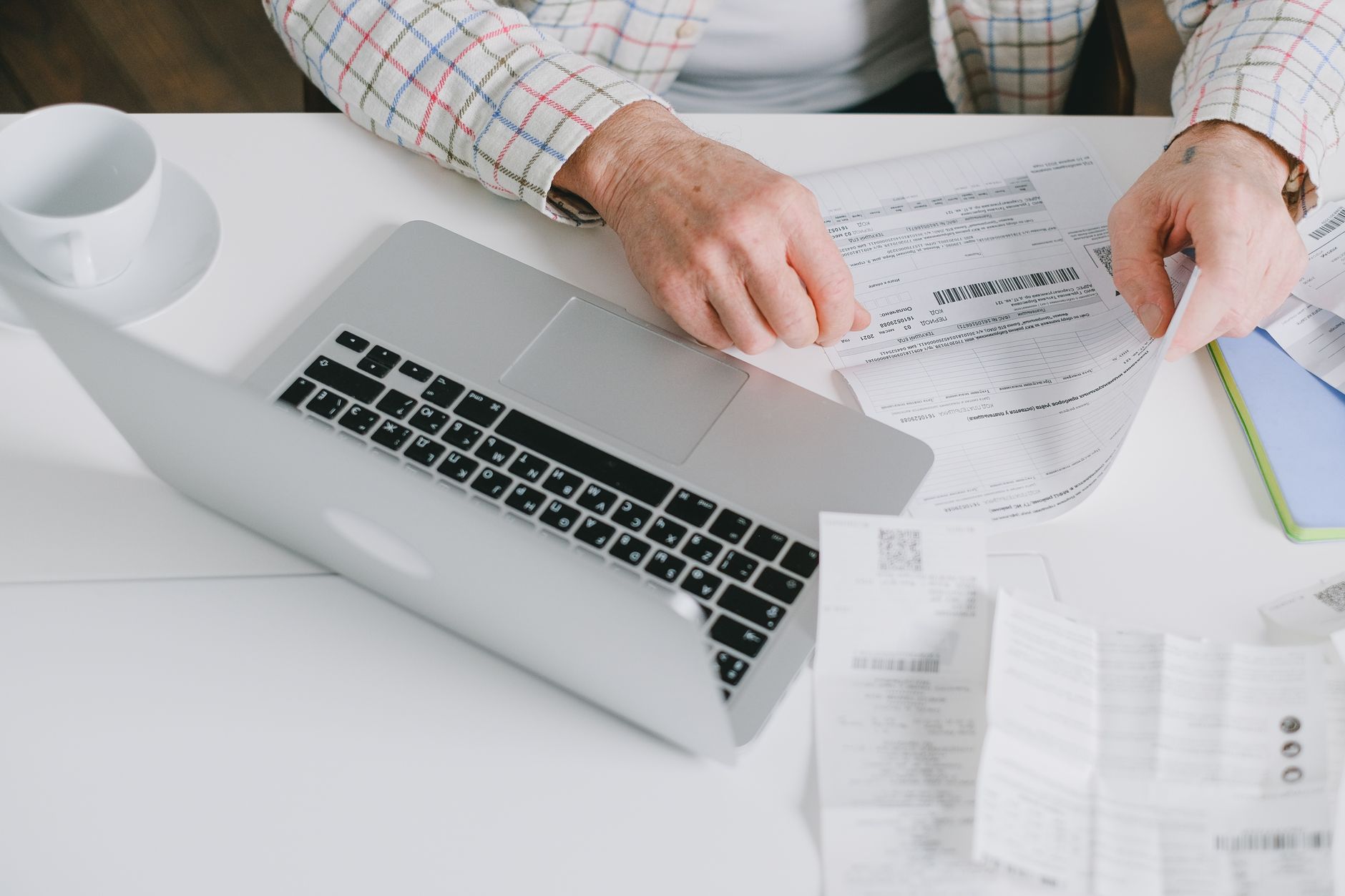 A person scanning paper receipts with a smartphone to save them digitally for HSA tracking