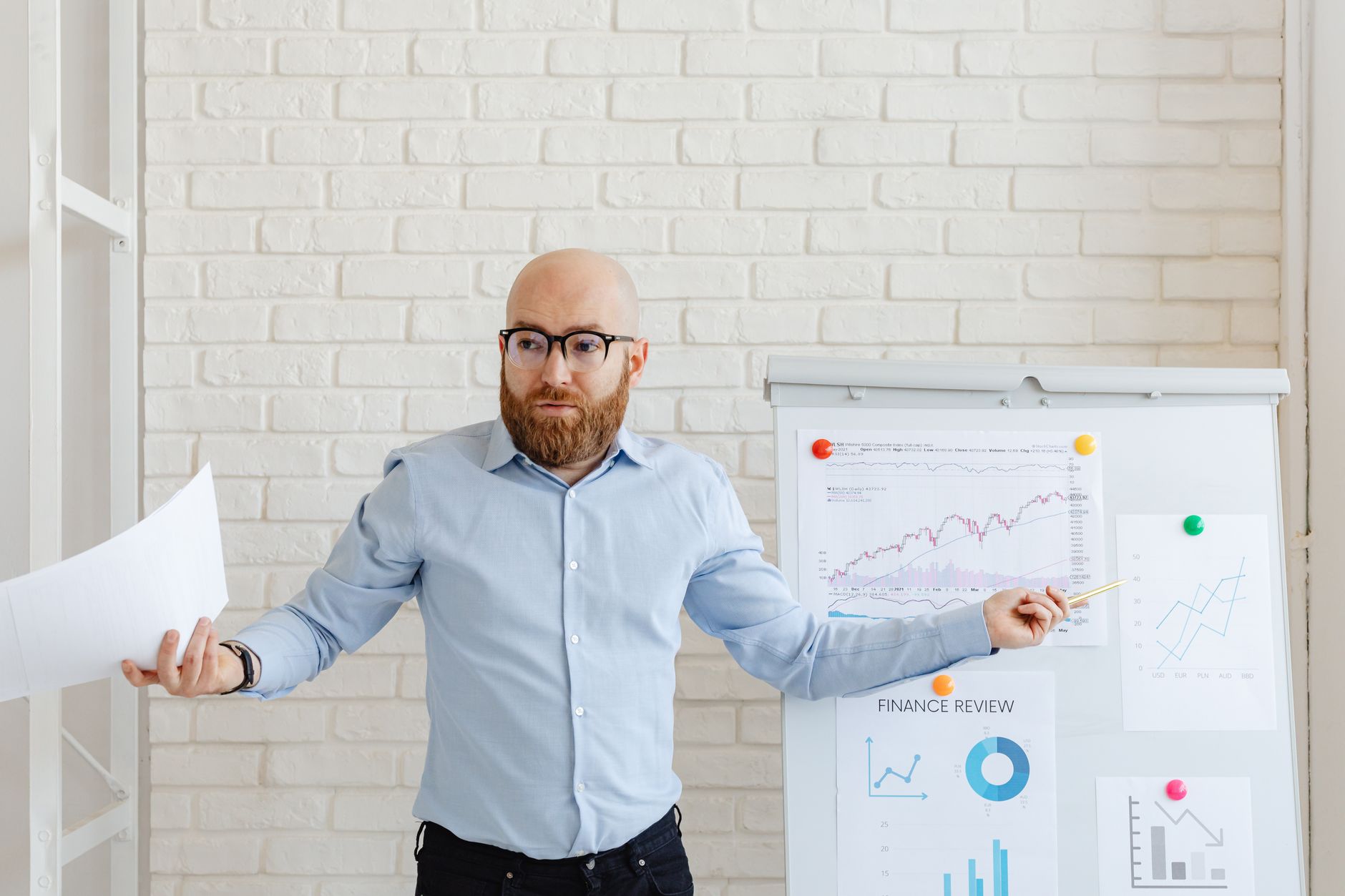 A focused man in business casual attire reviews financial charts on a tablet, symbolizing strategic retirement planning and decision-making between Roth IRA and 401(k).