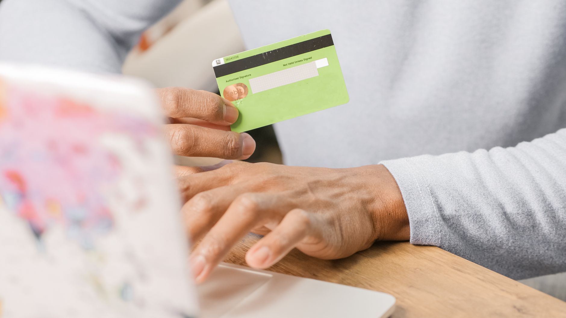 Person using laptop to freeze credit online at Equifax website with security shield graphics overlay