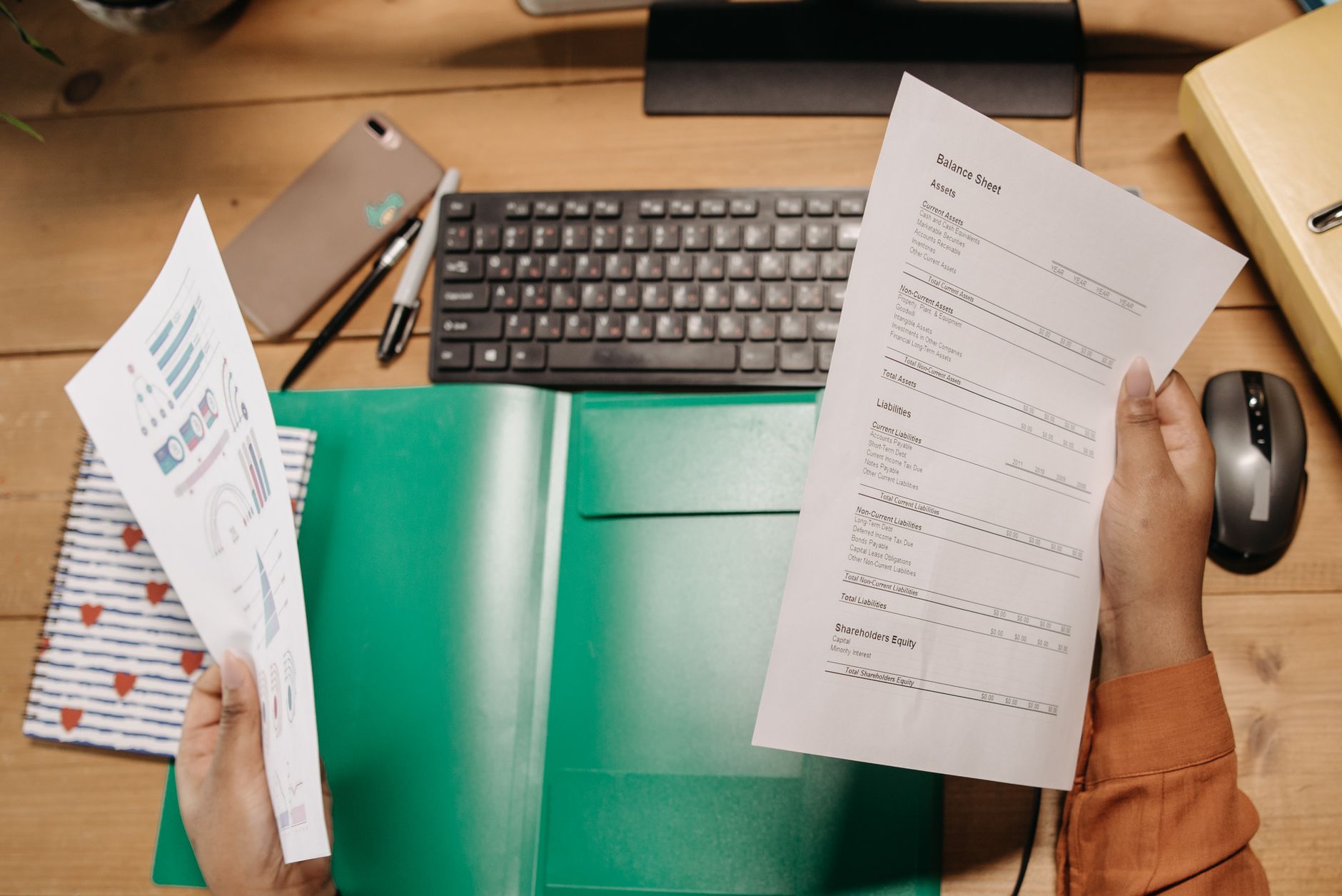 A person analyzing their monthly credit card statements on a tidy wooden desk, representing responsible credit management.