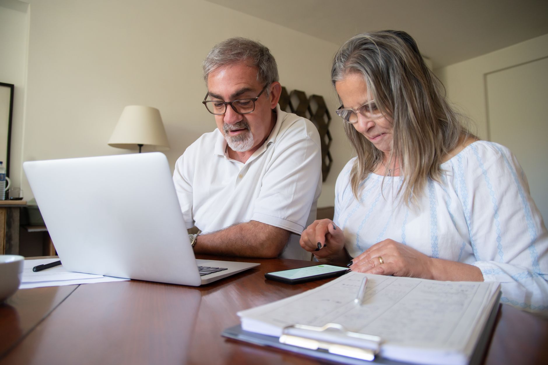A wealthy couple sitting at a desk planning their retirement using a backdoor roth ira strategy