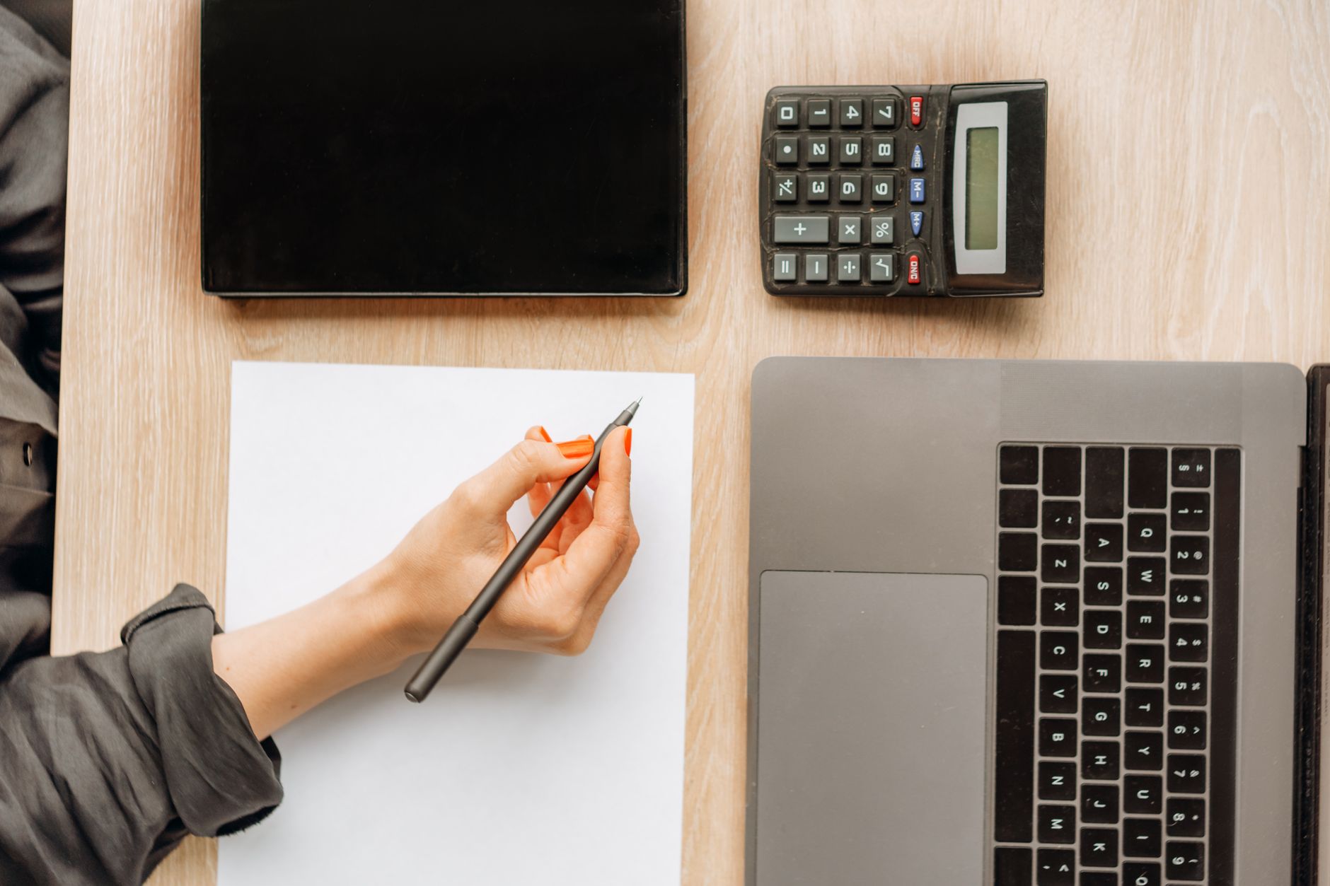 A person using a calculator to figure out if car insurance coverage is worth the cost