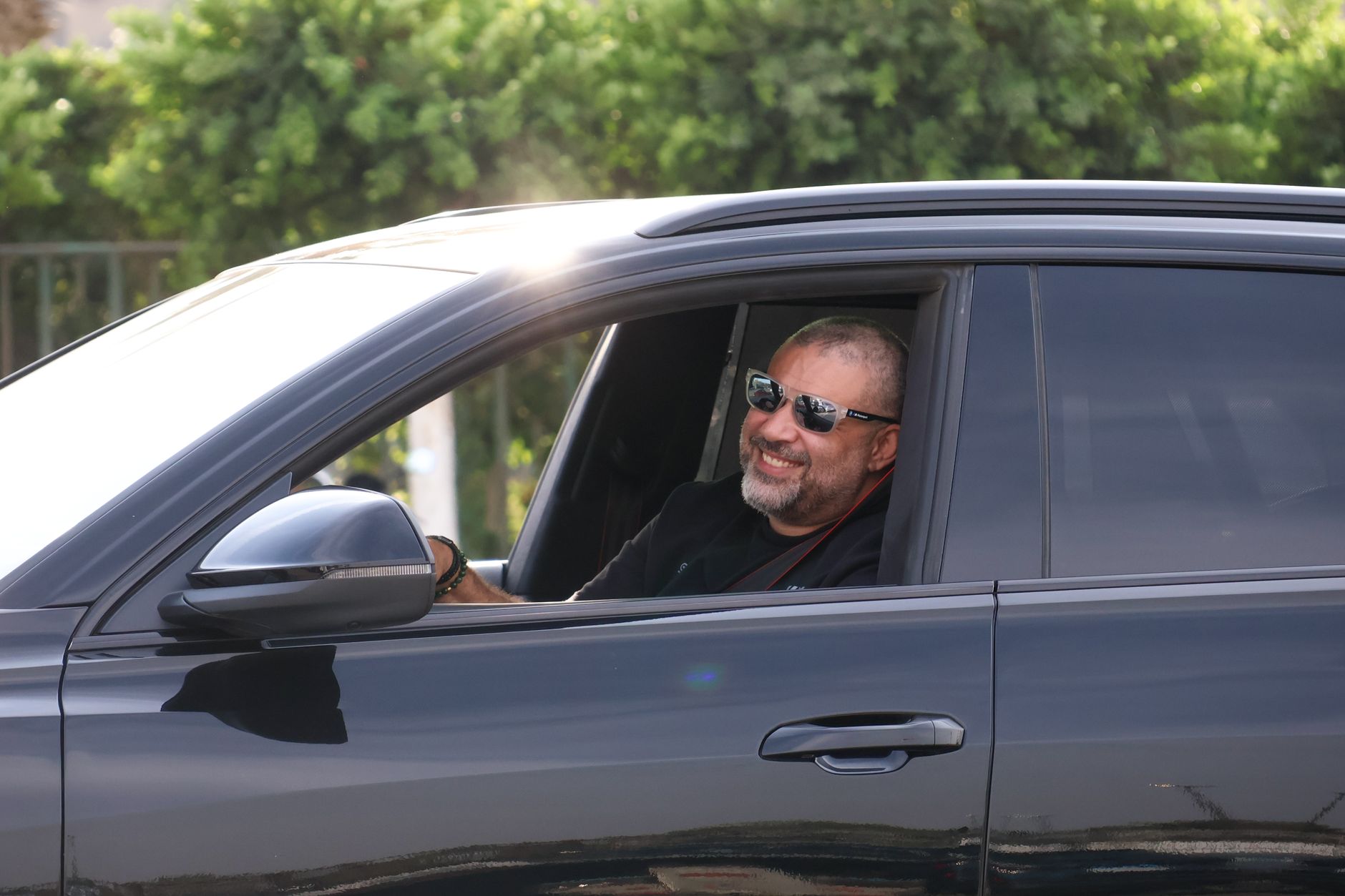 A smiling driver in a clean, modern car enjoying affordable auto insurance rates