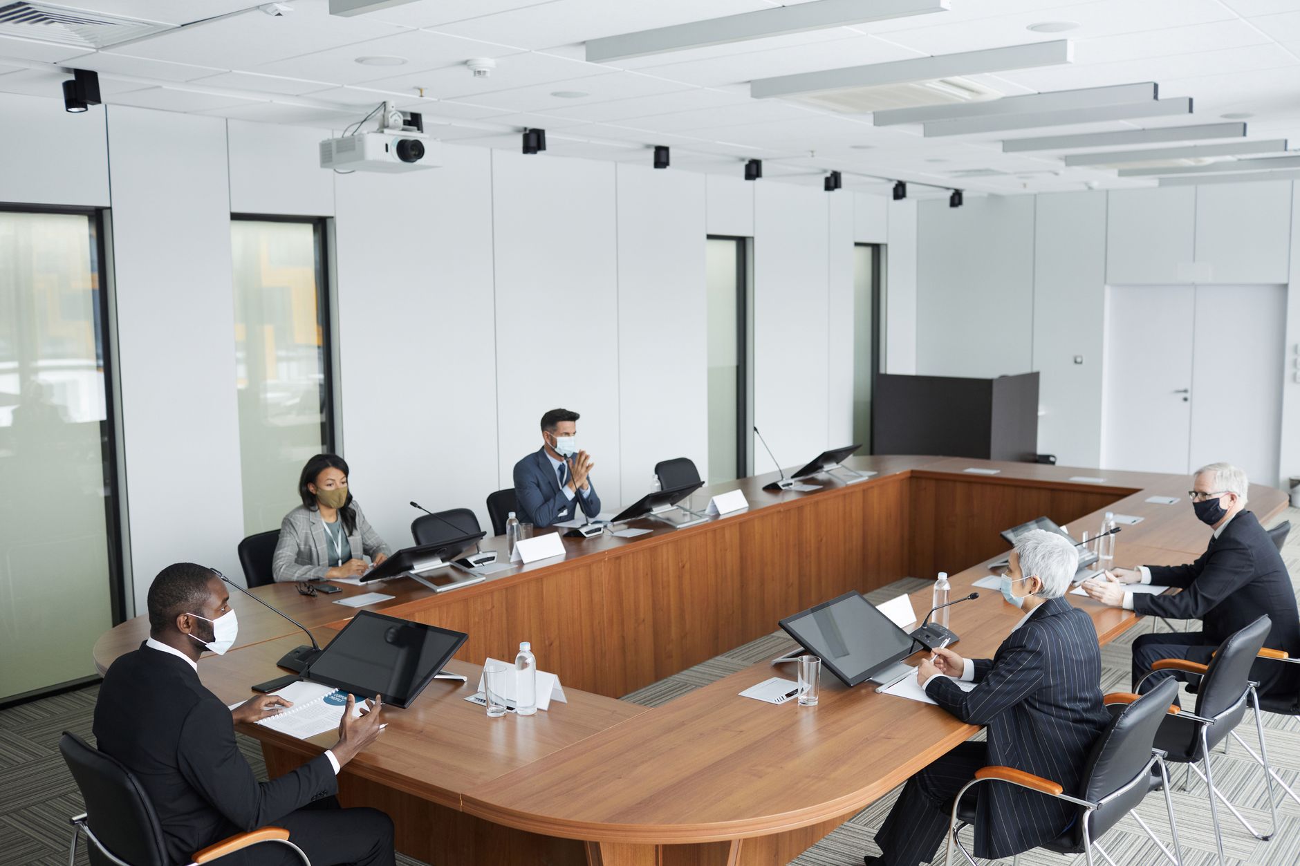 Business executives in a professional boardroom reviewing financial charts and discussing corporate earnings distribution