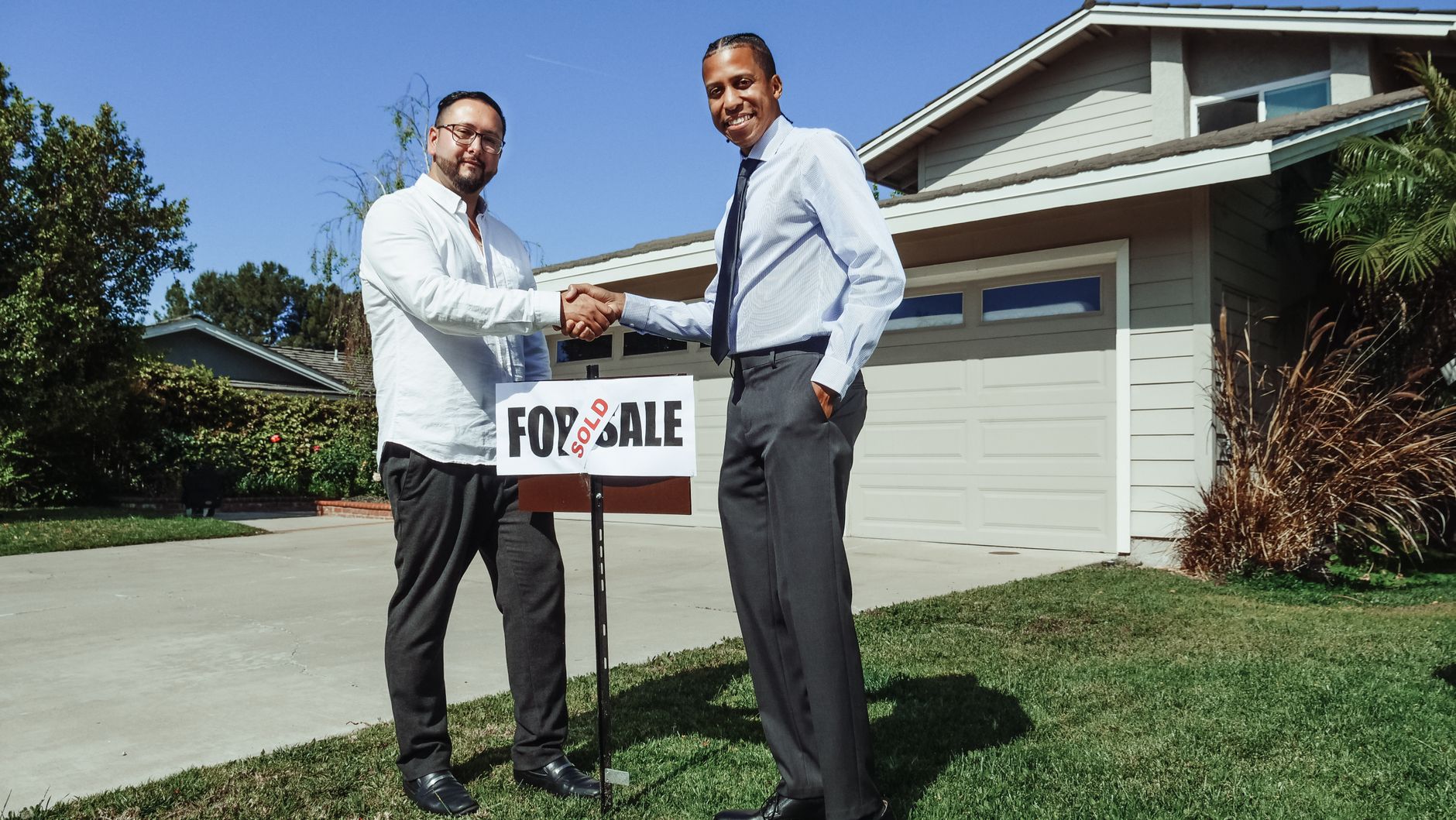 A real estate agent shaking hands with a client in a modern office