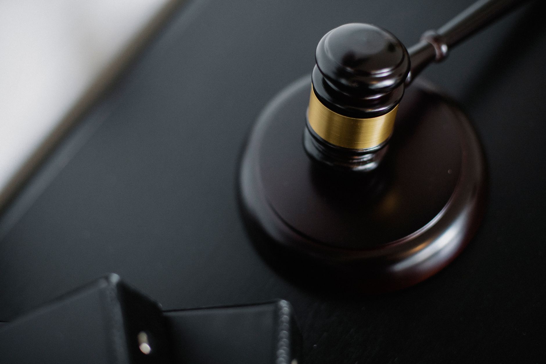 A wooden gavel resting on a shield symbolizing legal protection and liability coverage