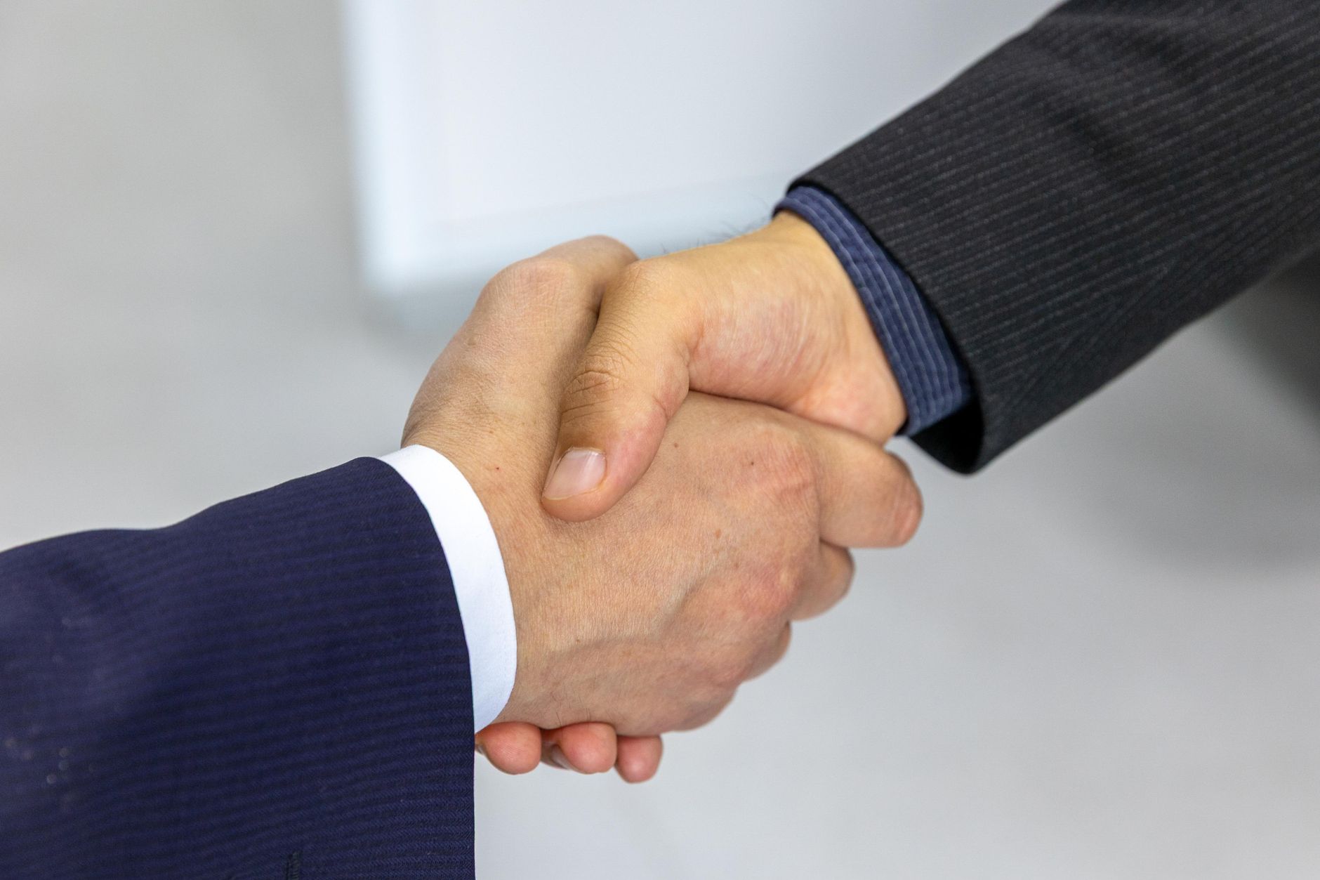 Two professionals shaking hands in an office, symbolizing a career promotion and salary raise without tax penalties.