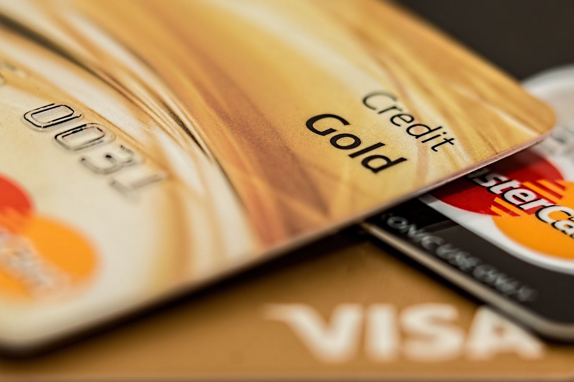 A close-up of a consumer examining their credit card details on a physical card
