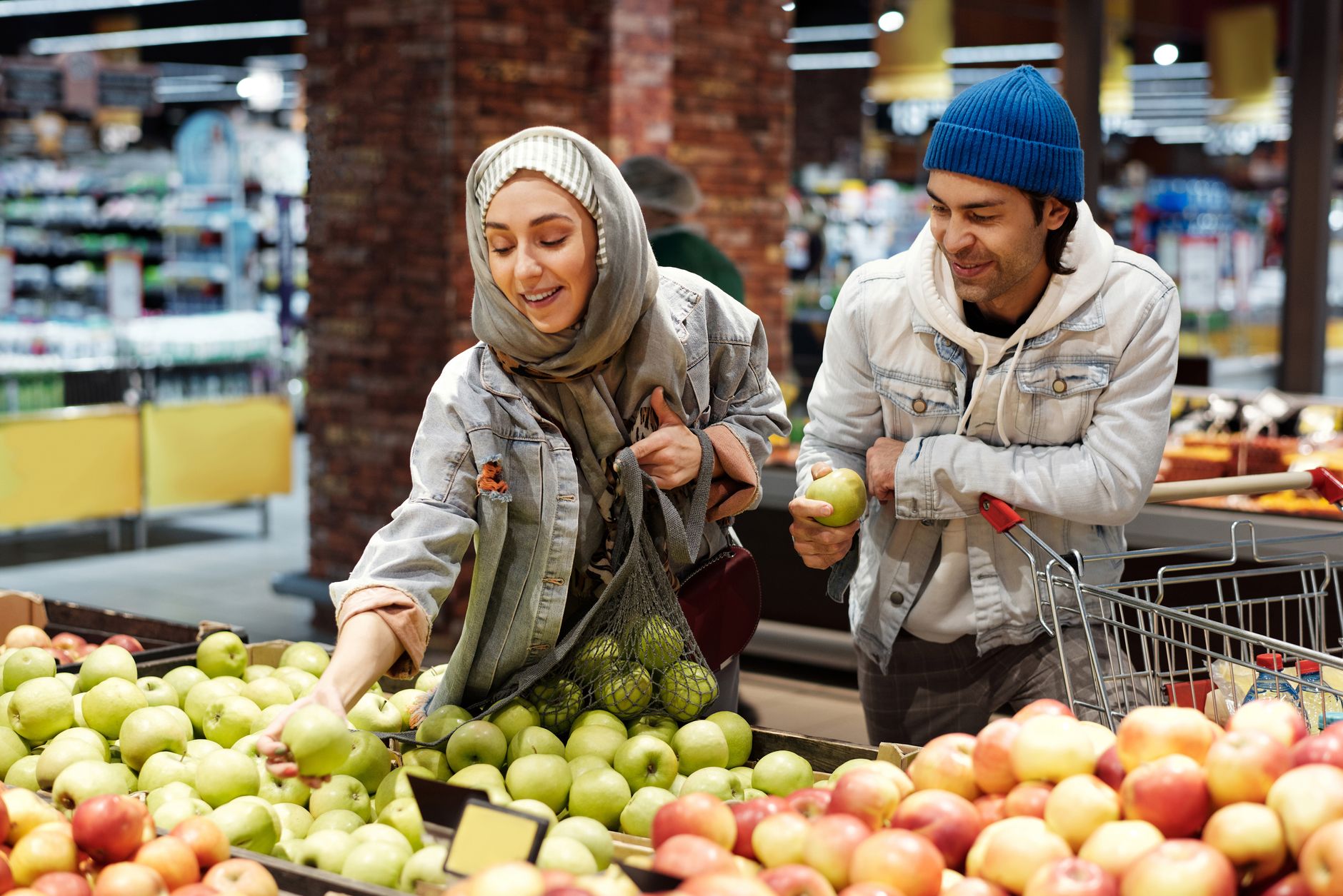 A person comparing grocery prices in a store, emphasizing smart budgeting decisions