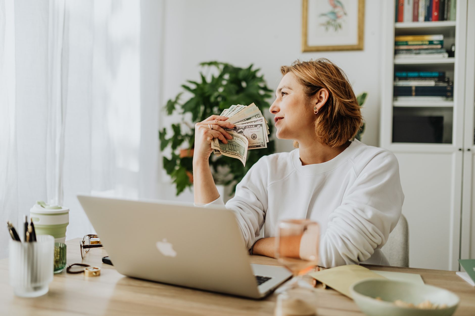 A remote worker managing a side hustle on their computer to boost income