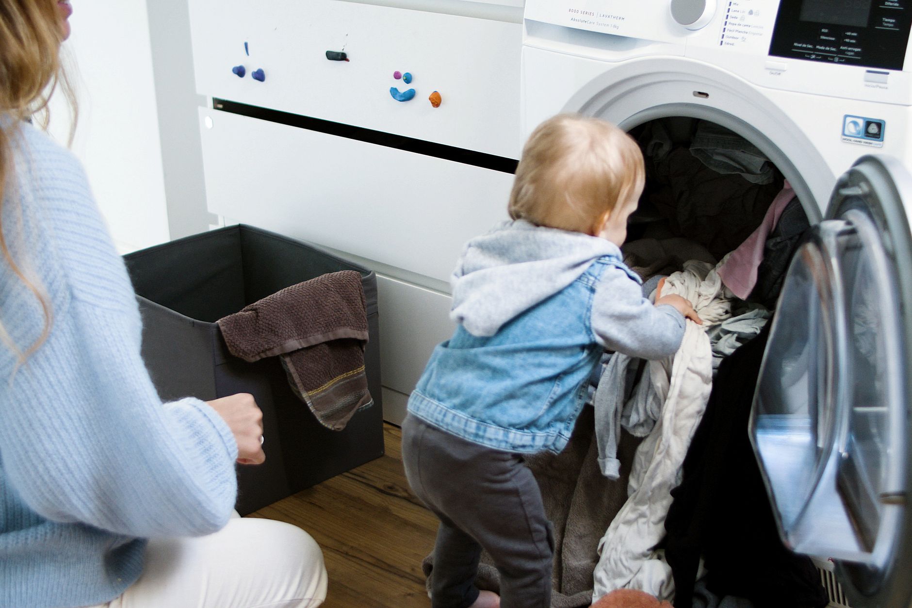A young boy checking off completed tasks on a colorful chore chart on the refrigerator