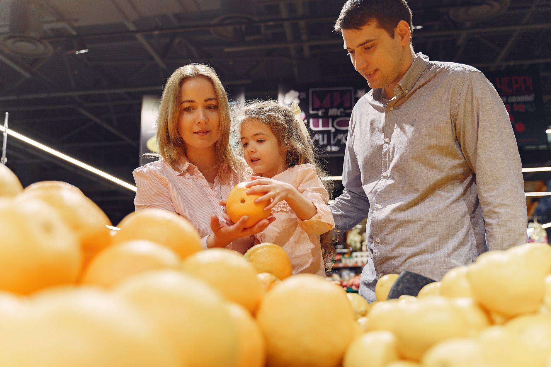 A father and daughter comparing grocery prices using a calculator app on a smartphone