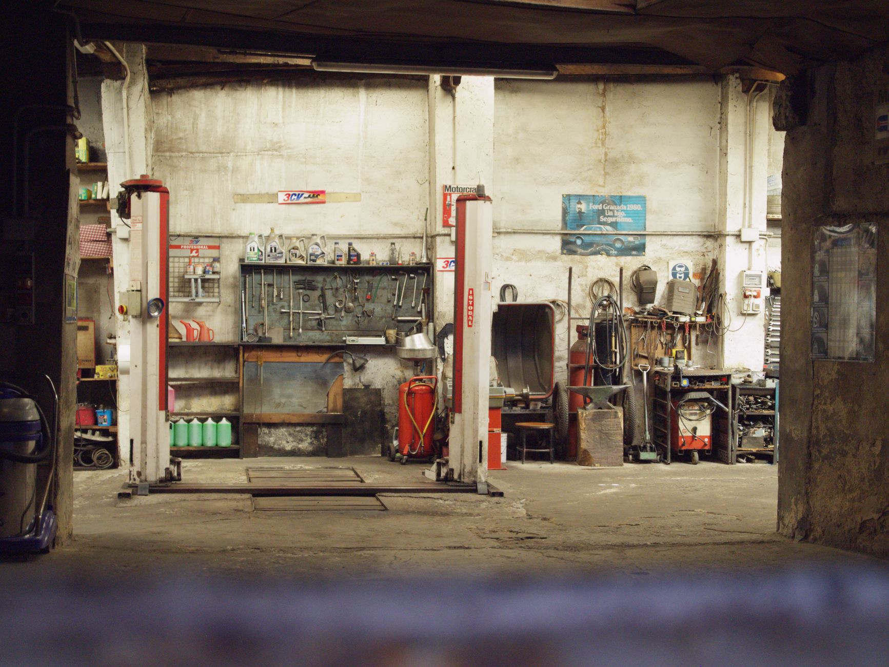 A mechanic inspecting a car engine in a clean, modern vehicle repair shop