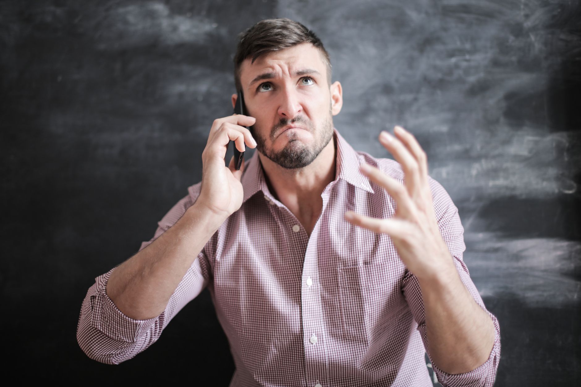 A person looking concerned at their smartphone showing a credit monitoring alert about high utilization