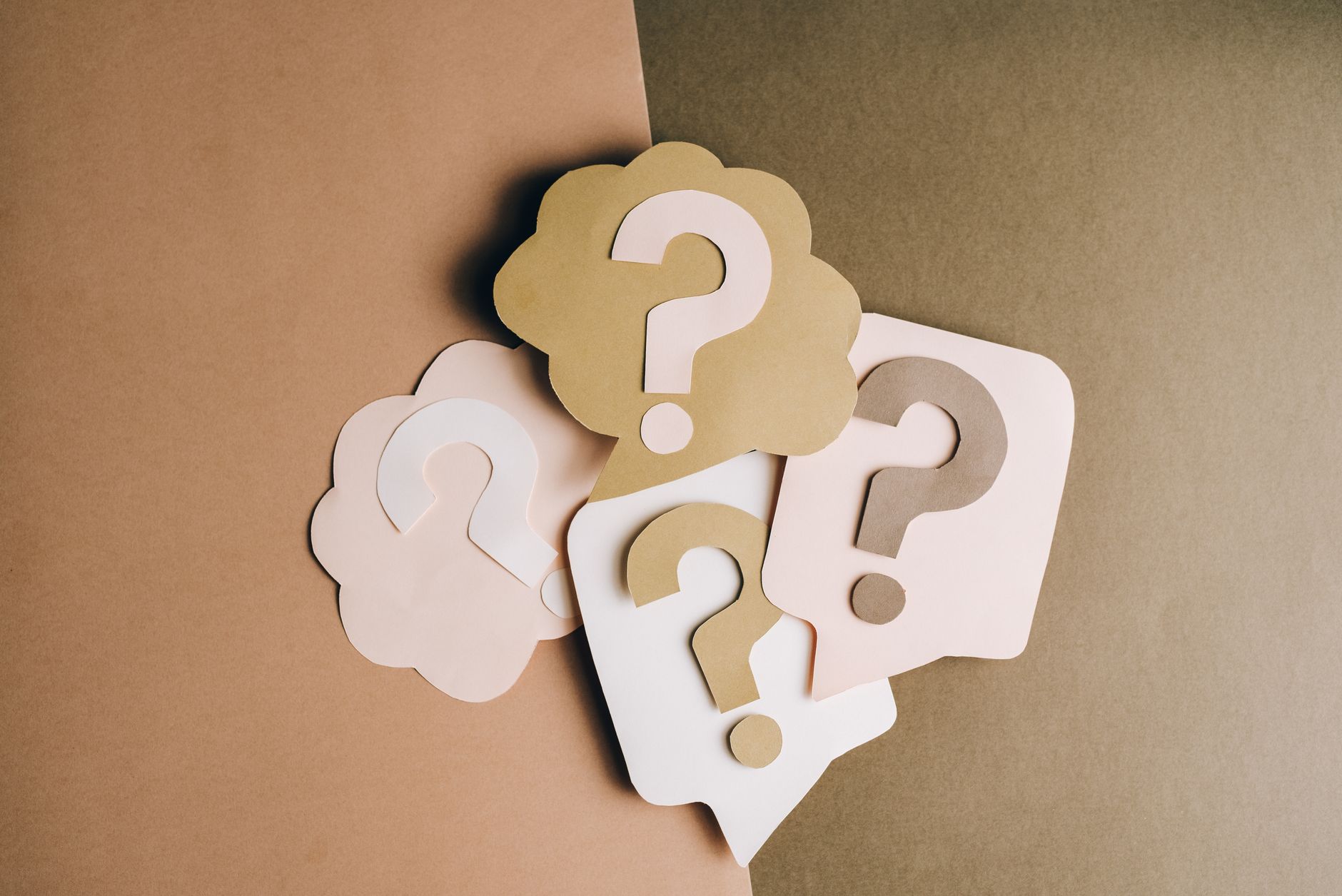 A question mark icon over a split background of a laptop and a bank building