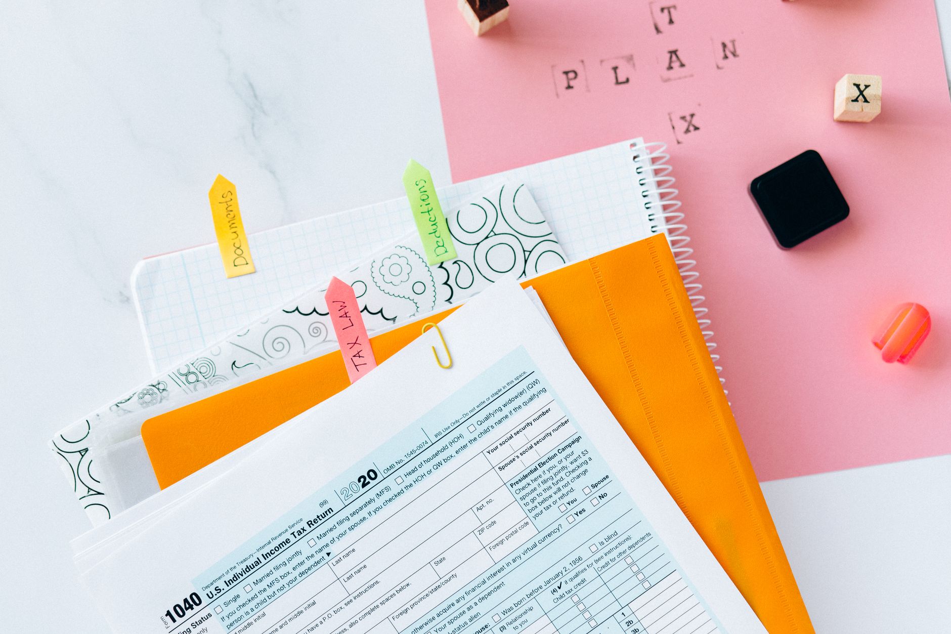 Tax forms and a calculator on a desk representing pre-tax vs Roth retirement planning