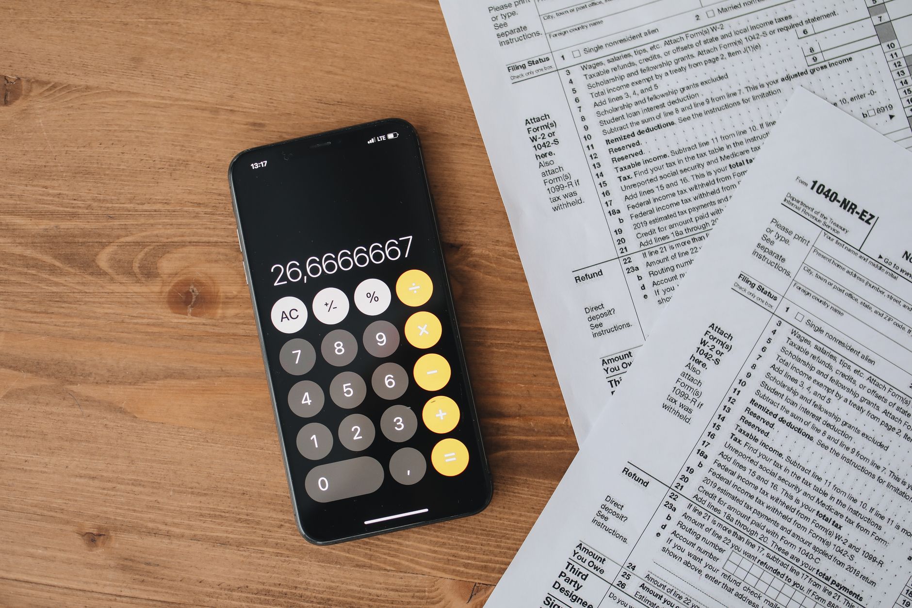 A person reviewing tax forms and a calculator to illustrate how deductions lower taxable income