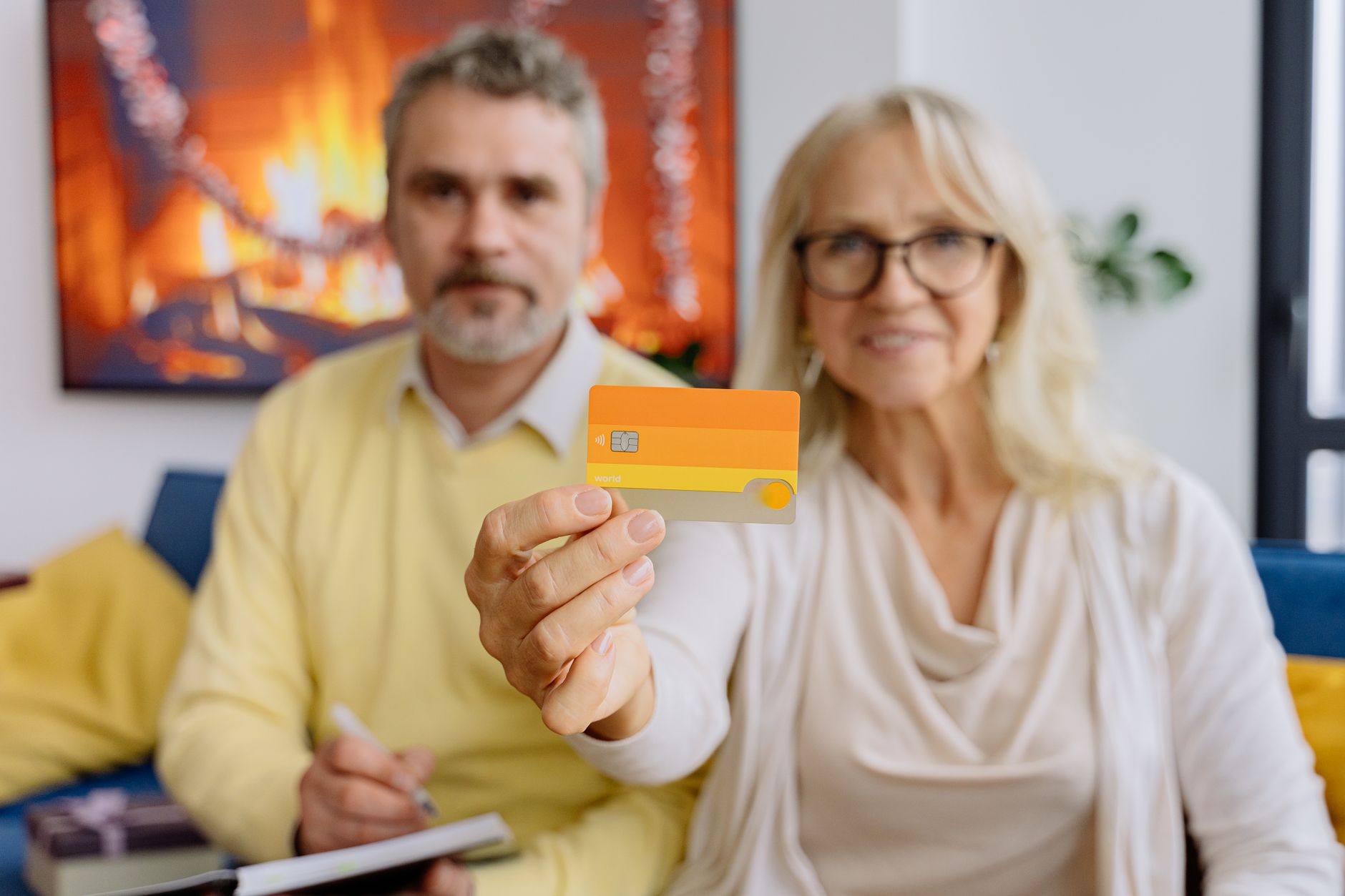 A parent handing a credit card to a young adult, illustrating the difference between authorized user status and cosigning