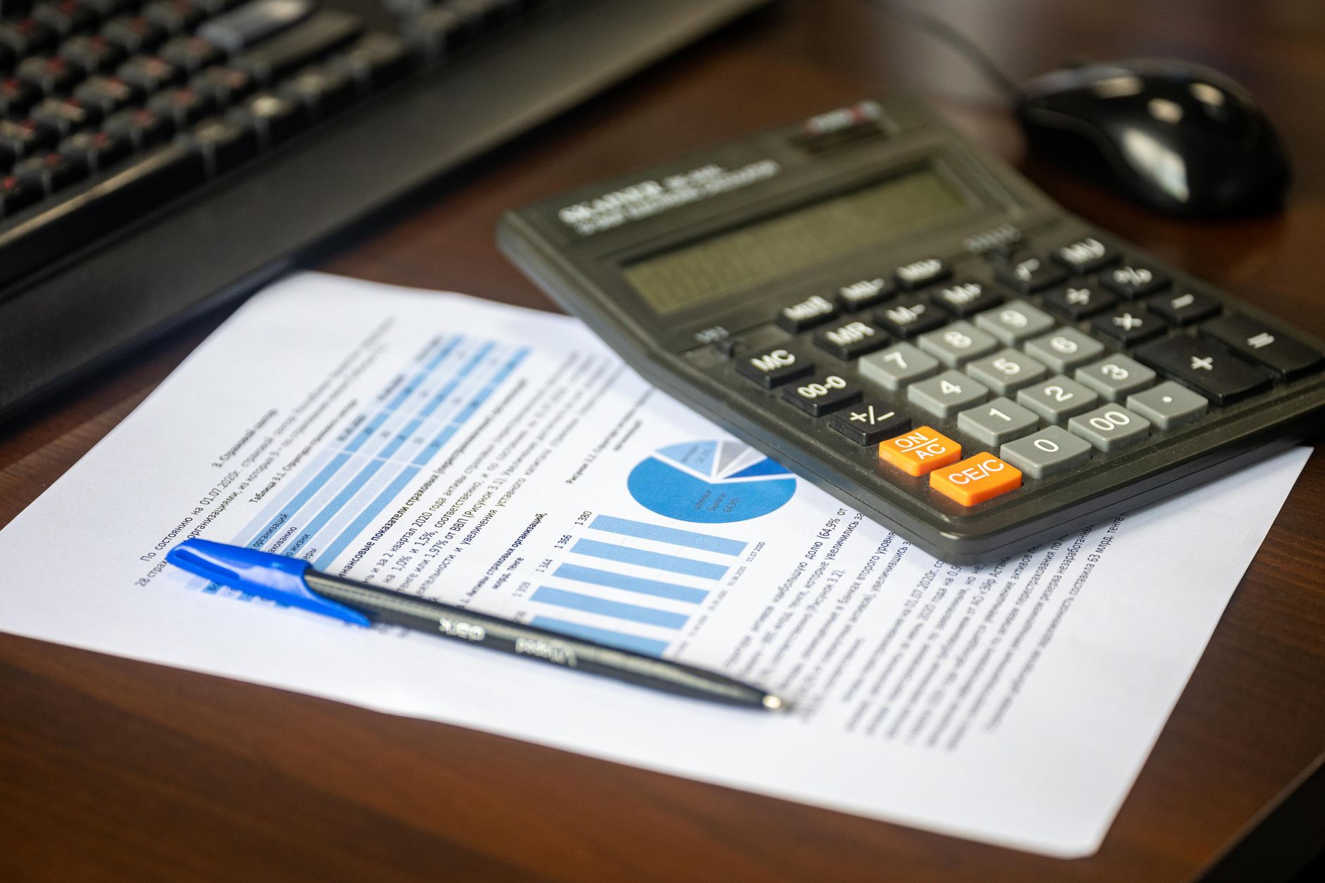 A person using a calculator and retirement plan statements to calculate vested benefits before leaving a job.